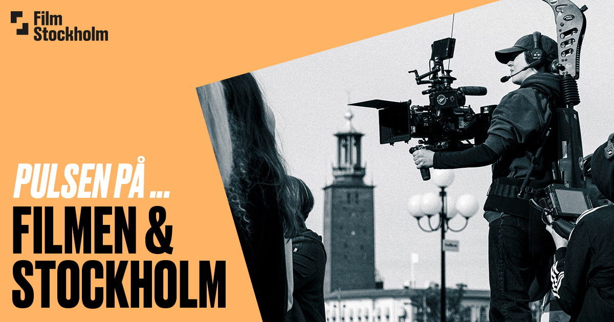 Syntolkning. Svartvit bild på filmfotograf med kamera med Stockholms stadshus i bakgrunden.