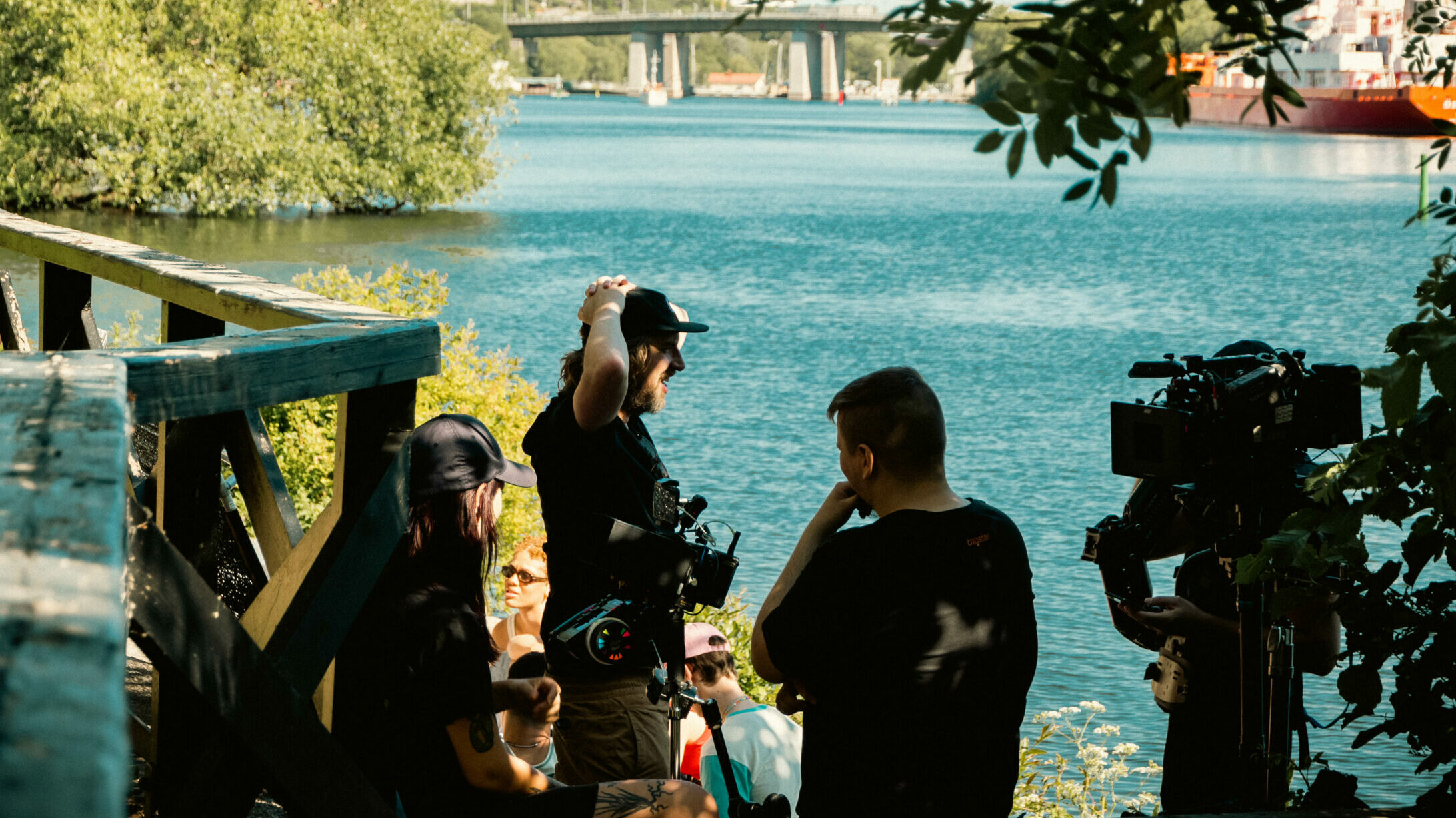 Filmteam arbetar omgivet av grönska och vatten.