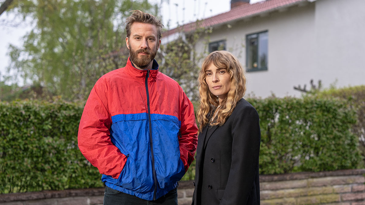 En man och en kvinna står framför en villa.