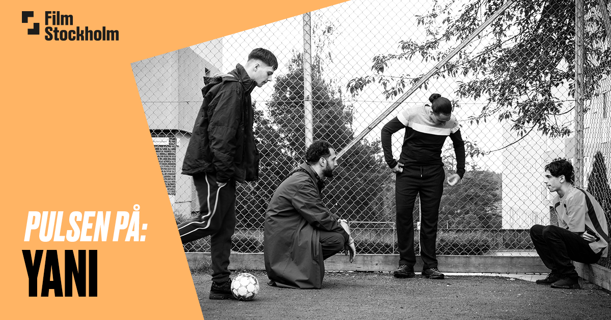 Fyra personer talar med varandra på en fotbollsplan.