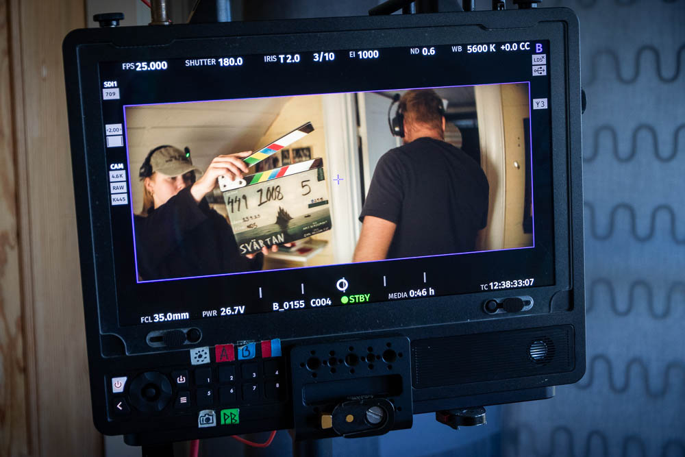 Inspelningsmonitor som visar en filmarbetare med en klappa.