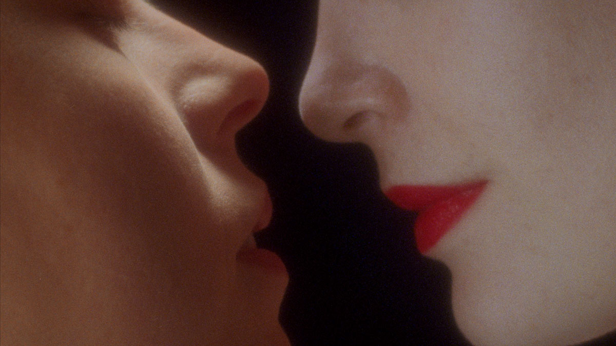 Närbild på två munnar som är på väg att kyssas.