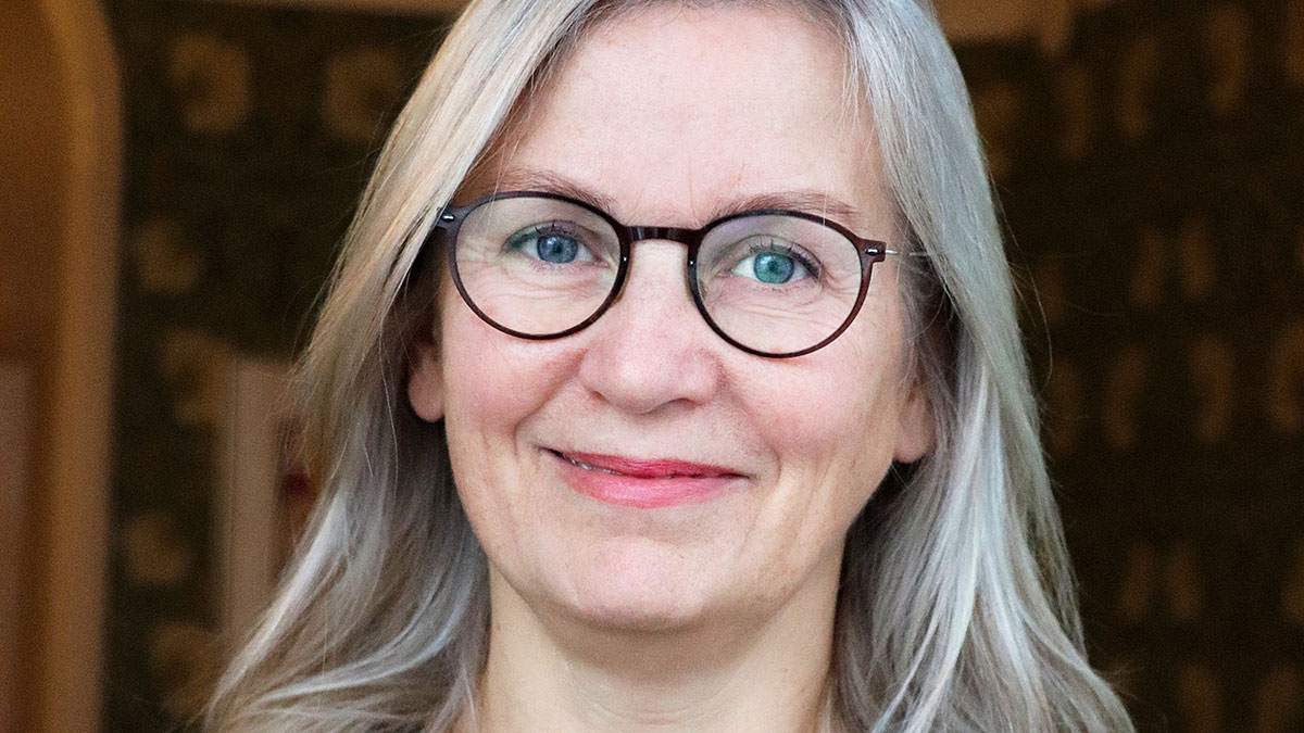 Närbild på leende kvinna som tittar in i kameran.